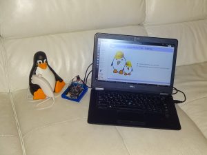 Tux working on embedded Linux on a couch